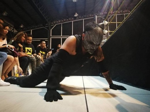 The Apocalypse struggles to his feet after taking a shot from SANDATA outside the ring.